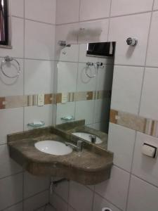 a bathroom with a sink and a mirror at Esplendor Palace Hotel in Vitória da Conquista