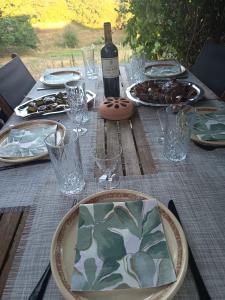 a table with plates of food and a bottle of wine at La Belgastide chambre d'hôte in Quins
