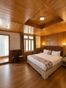 a bedroom with a large bed and wooden ceilings at Lecoxy Resort in Lachung