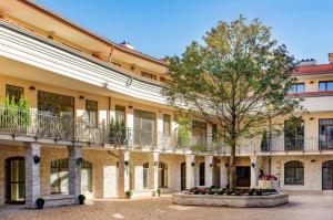 a large building with a tree in a courtyard at Vilnius Apartments & Suites – Old Town in Vilnius