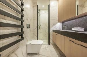 a bathroom with a toilet and a glass shower at Vilnius Apartments & Suites – Old Town in Vilnius +209 photos
