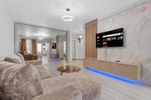a living room with a couch and a tv on a wall at Vibe Luxury Studio - Militari Residence - Parcare Privata Gratuita in Chiajna
