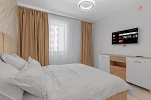 a bedroom with a white bed and a television at Vibe Luxury Studio - Militari Residence - Parcare Privata Gratuita in Chiajna