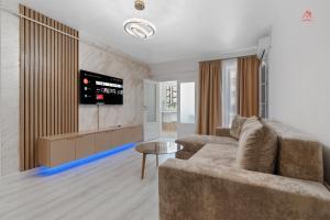 a living room with a couch and a tv at Vibe Luxury Studio - Militari Residence - Parcare Privata Gratuita in Chiajna +8 photos