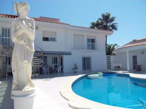 a statue of a woman standing next to a swimming pool at Apartment Los Eucaliptus in L'Eucaliptus