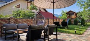 a patio with a table and chairs and an umbrella at Котедж Gudz in Yaremche