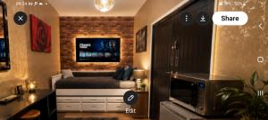 a bedroom with a bed and a tv on the wall at Phoenix Nights Guest House in Barrow in Furness