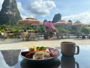 a plate of food on a table with a coffee cup at Yangshuo Hidden Dragon Villa in Yangshuo