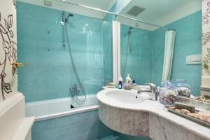 a bathroom with a shower, sink, and tub at Europa Hotel Design Spa 1877 in Rapallo