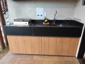 a kitchen counter with a sink and a microwave at Naay Villas - Flat Beira Mar - Sao Miguel dos Milagres in Pôrto de Pedras