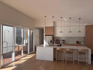 a kitchen with a counter and a kitchen island with chairs at Tiberius House in Saint Andrews Beach