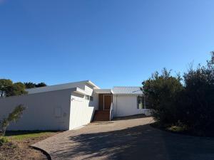 a white house with a driveway in front of it at Tiberius House in Saint Andrews Beach