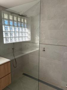 a shower with a glass door in a bathroom at Tiberius House in Saint Andrews Beach +18 photos