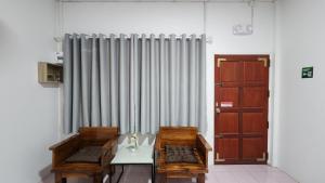 a room with two benches and a table and a door at 338 House in Ban Liam