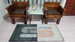a room with two chairs and a table and a rug at 338 House in Ban Liam