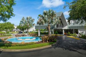 a building with a swimming pool and a palm tree at Marriott's Sabal Palms in Orlando
