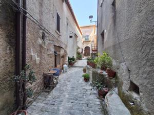 an alley with chairs and potted plants in an alley at #3MTSOPRAILCIELO '' SCuLPTuRe '' in Felitto
