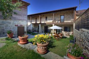 a garden with pots of flowers in front of a building at Casa Ramiras in O Viso