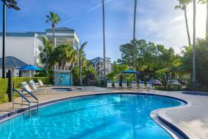 a swimming pool with chairs and a building at Marriott's Imperial Palms Villas in Orlando