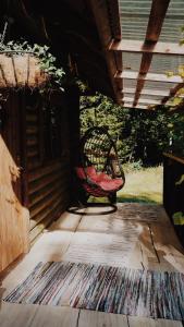a wicker chair sitting on the porch of a house at Härjamäe Saunamaja 