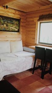 a bedroom with a bed and a desk and a window at Härjamäe Saunamaja 