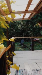 a wooden deck with a swing and a chair at Härjamäe Saunamaja  +3 photos