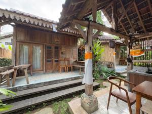 a patio of a house with a table and chairs at Arta Wooden House in Sukawati