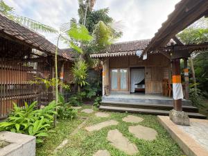 a guest house with a garden in front of it at Arta Wooden House in Sukawati