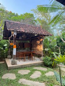 a wooden hut with a table in a garden at Arta Wooden House in Sukawati +6 photos