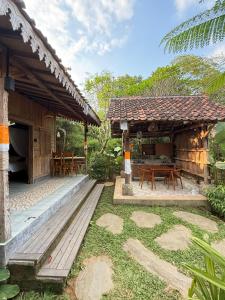 a house with a table and chairs in a yard at Arta Wooden House in Sukawati