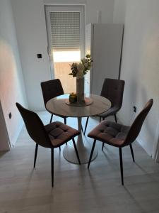 a table and chairs in a living room at Apartment Lunette in Mostar +8 photos