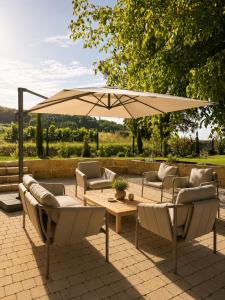 a patio with a table and chairs and an umbrella at Maison Meraka - Design Guest House of Saint Emilion in Saint-Laurent-des-Combes