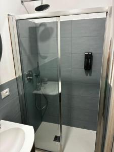 eine Glasdusche in einem Badezimmer mit Waschbecken in der Unterkunft Suite 13 in Pesaro
