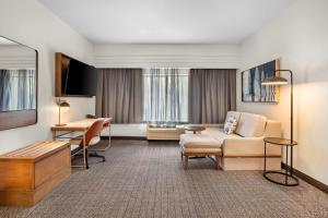 a hotel room with a couch and a desk at Courtyard by Marriott St. Augustine I-95 in St. Augustine