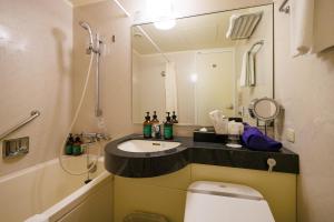 a small bathroom with a sink and a toilet at ANA Crowne Plaza Yonago by IHG in Yonago +39 photos