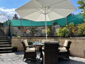 a table and chairs with an umbrella on a patio at The Apartment in Nairn