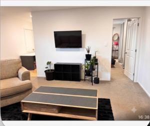 a living room with a couch and a tv on a wall at Dream House 5 in Auckland