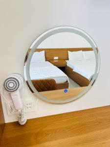 a bedroom with a mirror and a fan at THANH THỦY HoTel in Hà Tiên