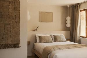 a bedroom with a bed and a window at Maison Meraka - Design Guest House of Saint Emilion in Saint-Laurent-des-Combes