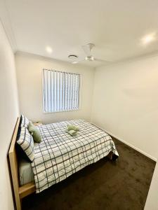 a bedroom with a bed and a window at Stylish place in Loganlea in Loganlea