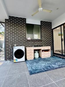 a room with a washing machine and a brick wall at Stylish place in Loganlea in Loganlea