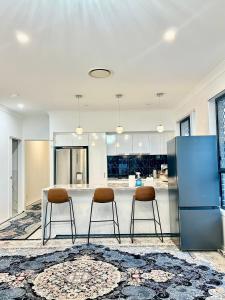 a kitchen with a table and two stools at Stylish place in Loganlea in Loganlea