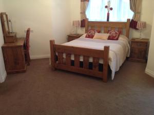 a bedroom with a wooden bed and two night stands at Crich Lane Farm in Alfreton