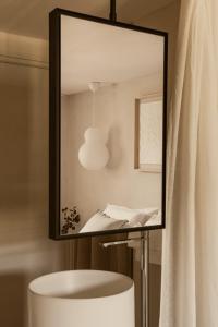 a mirror above a table in a bathroom with a lamp at Maison Meraka - Design Guest House of Saint Emilion in Saint-Laurent-des-Combes +90 photos