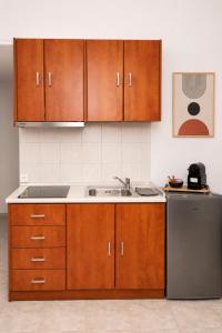 a kitchen with wooden cabinets and a sink and a refrigerator at Calithera in Samothraki