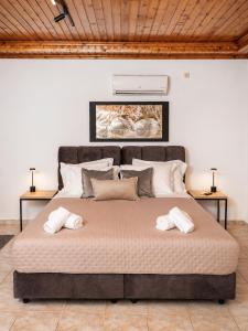 a large bed in a room with two towels on it at Calithera in Samothraki