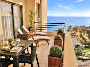 a balcony with a table and chairs and the ocean at MyOcean Luxury l Huge Panoramic Sea View Balcony & Private Garage in Portimão
