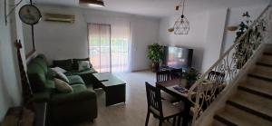 a living room with a green couch and a table at Duna Hollidays in Puerto de Sagunto
