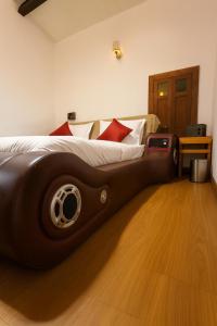 a bedroom with a large bed with a wooden floor at Secret Escape Colonial Bungalow in Ooty +33 photos