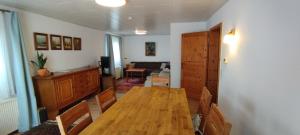 a dining room with a wooden table and a living room at Ferienhaus Feldbrise in Gottesgabe